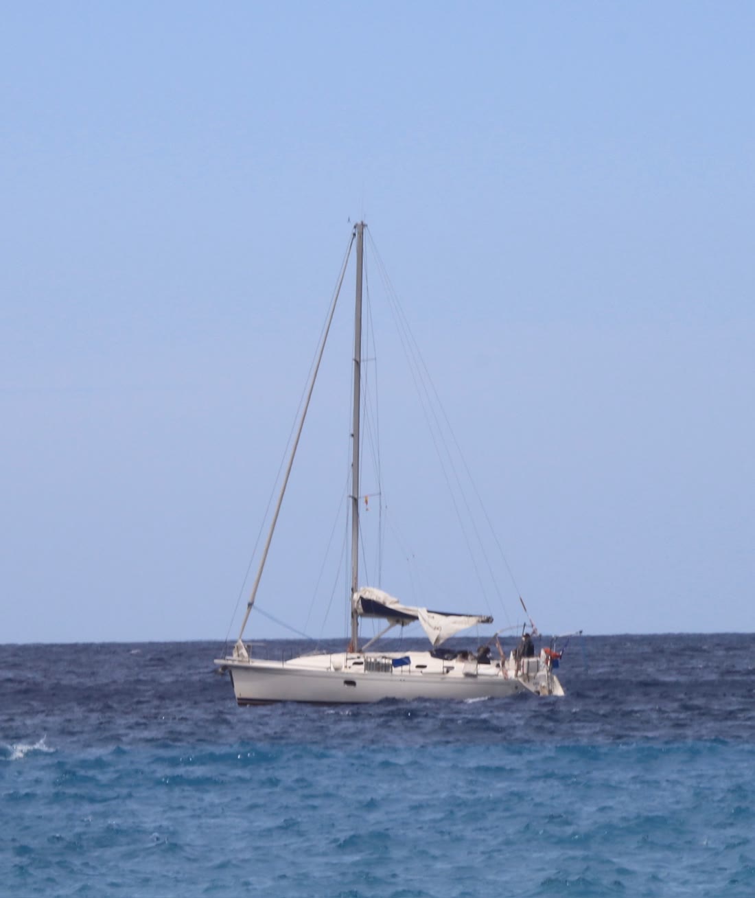 A sailboat anchored on open blue water